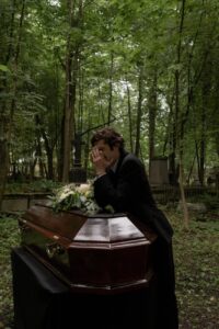 grieving man crying beside the coffin